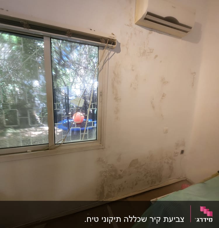 קיר עם סימני רטיבות לפני צביעה